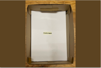 caixa de cartão com uma folha branca, tendo a palavra "acontecimento" escrita no centro da folha